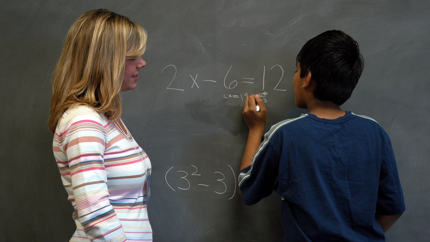 老师和学生在黑板前交谈