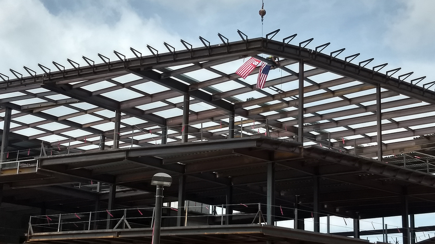工人们将钢梁安装到新的健康和娱乐中心的结构上。