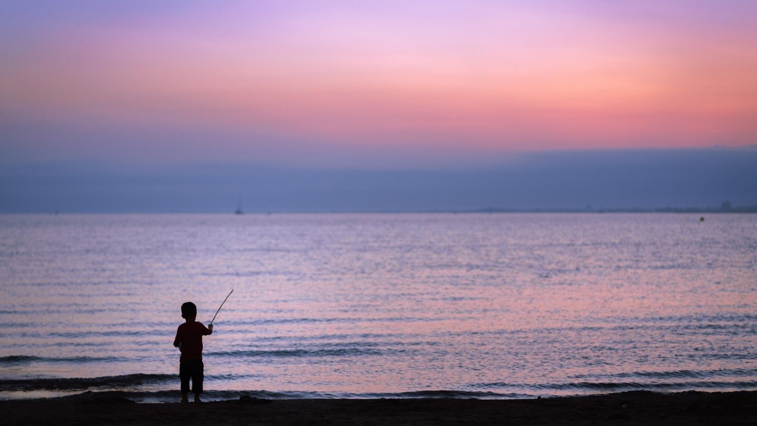 一个钓鱼的孩子的剪影。
