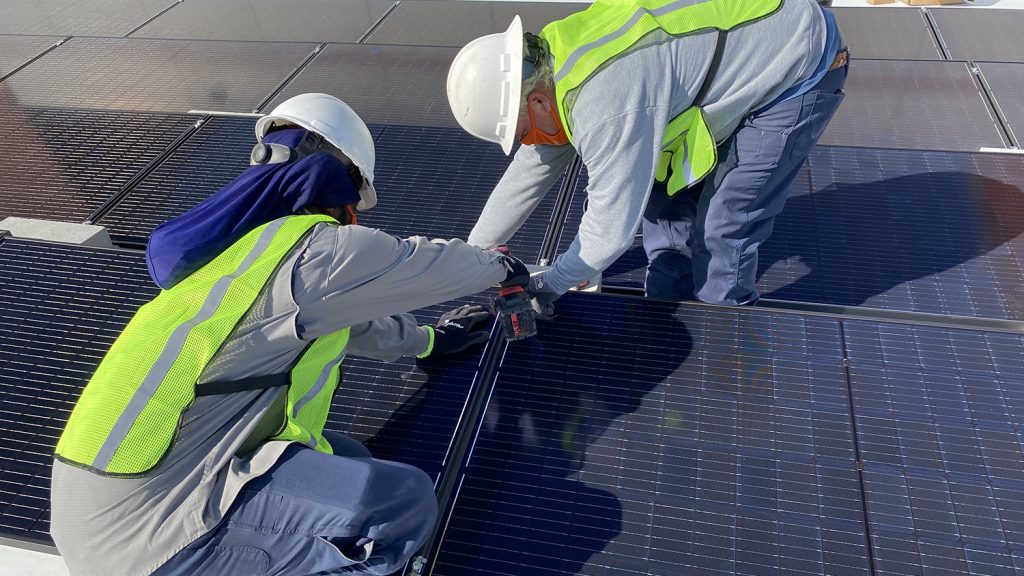 工人将太阳能电池板放置到位。