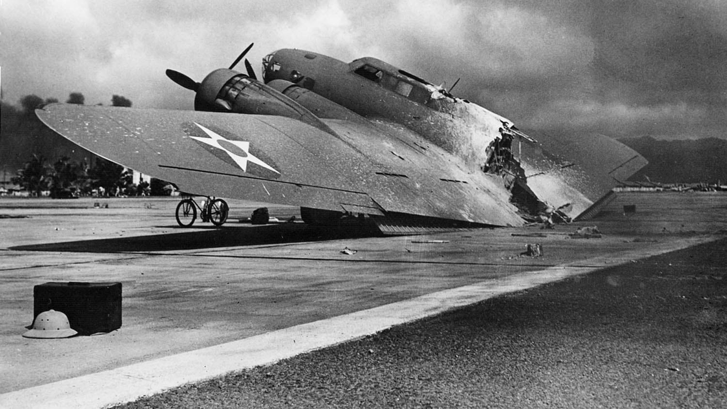 1941年12月7日，夏威夷瓦胡岛希卡姆机场，一架被烧毁的美国陆军空军波音B-17C飞行堡垒停在5号机库附近。图片来源:国家档案馆。
