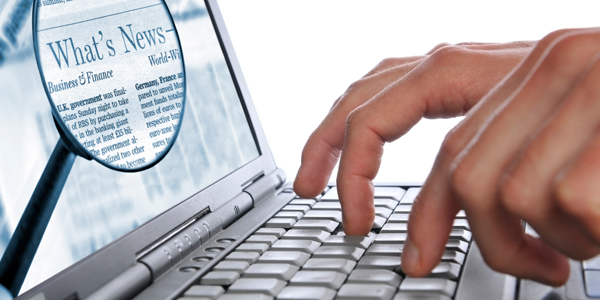 手在笔记本电脑上打字，屏幕放大，新字高亮显示。