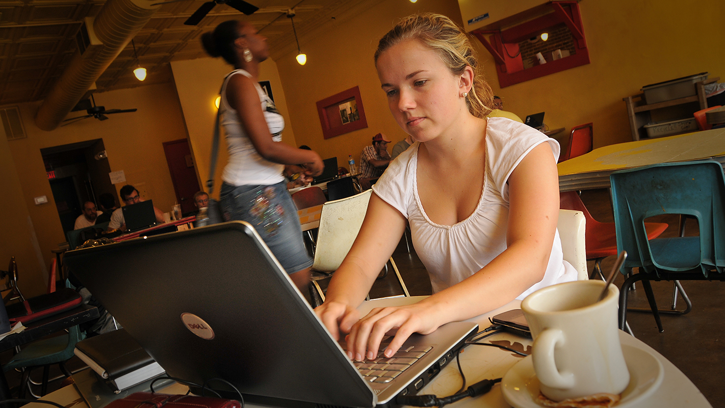 学生在咖啡店用笔记本电脑。