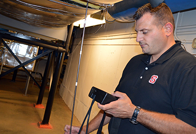 Adam Renzi是一名设备机械工程师和重新调试团队的负责人，他在工程大楼I进行空气平衡。