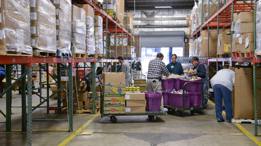 北卡罗莱纳中部和东部的食品银行的买家在罗利分行的过道上分类食品。