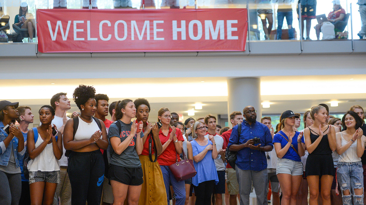 在尊重2016年尊重的“欢迎家”横幅下聚集的学生。