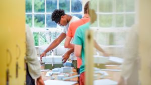 一个年轻人排队泡沫块以创造一个建筑模型。