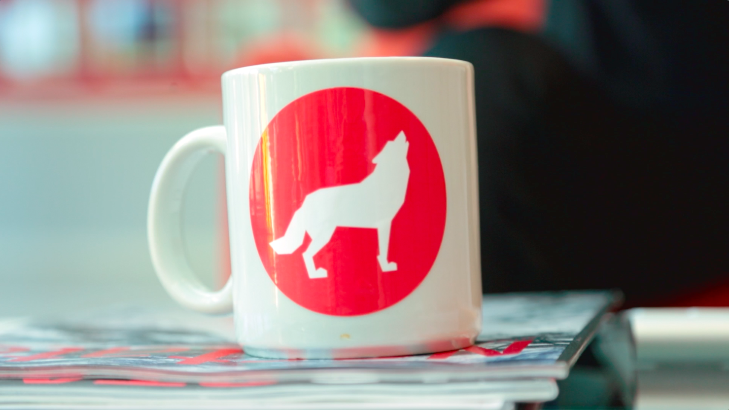 NC州立咖啡杯坐在一堆NC州立校友会杂志上。