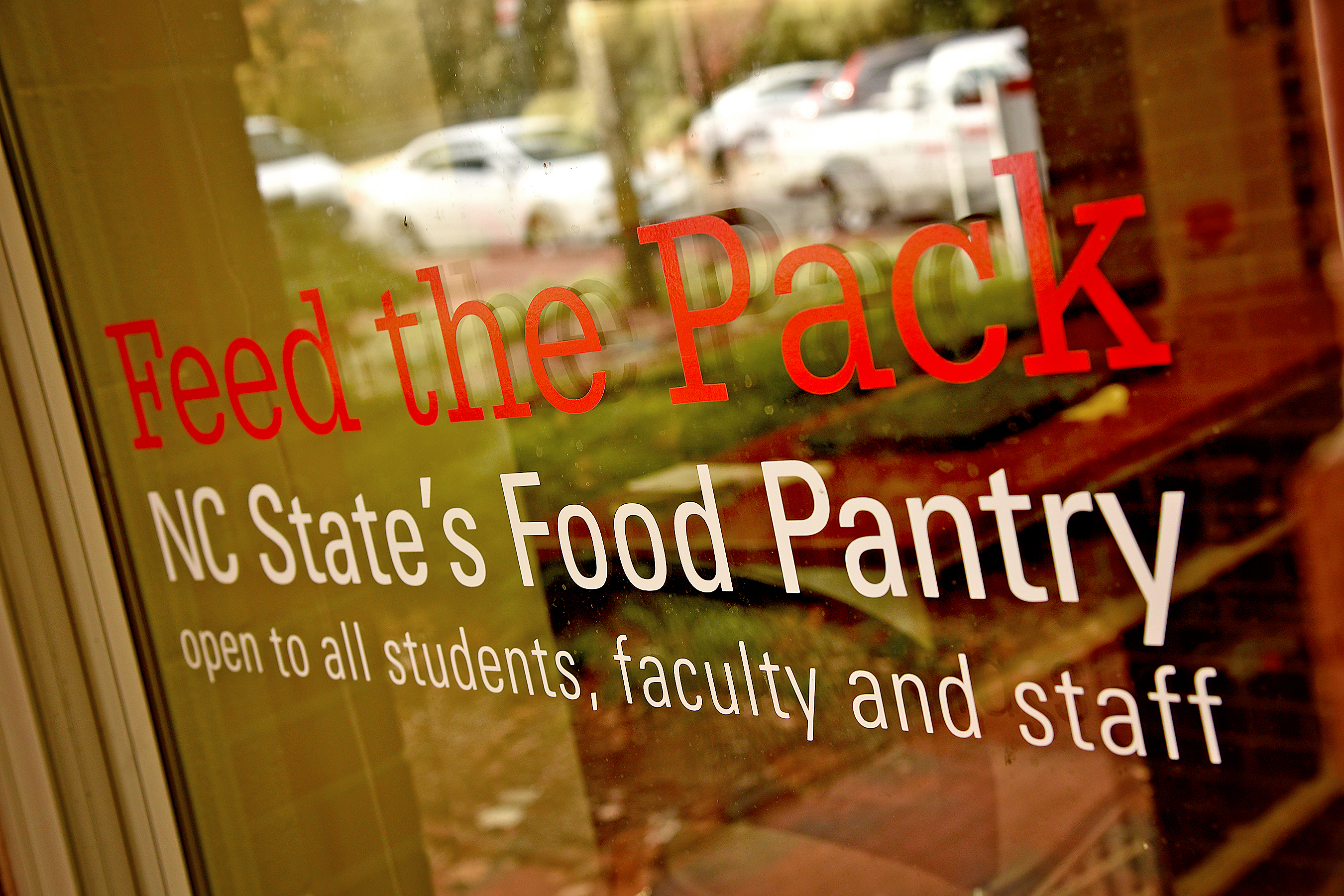 玻璃门上的标牌上写着:“向所有学生、教师和工作人员开放，北卡罗来纳州的食品分发处。”