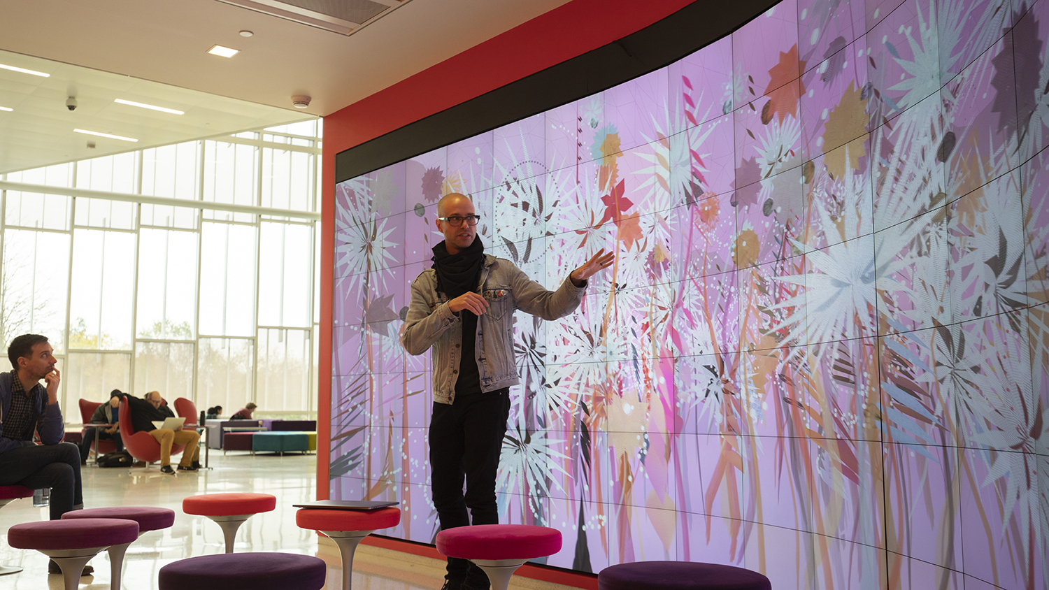 一个男人站在亨特图书馆的电脑显示器旁边。