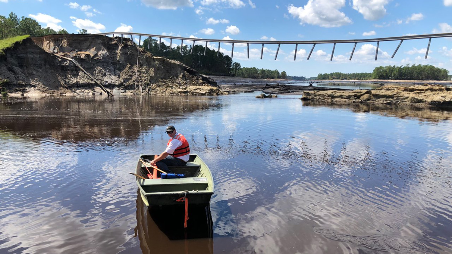 有人在被冲坏的道路下划船