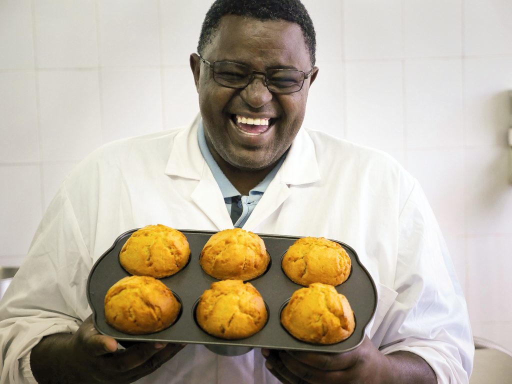 有拿着甜土豆松饼盘子的有高兴的微笑的人。