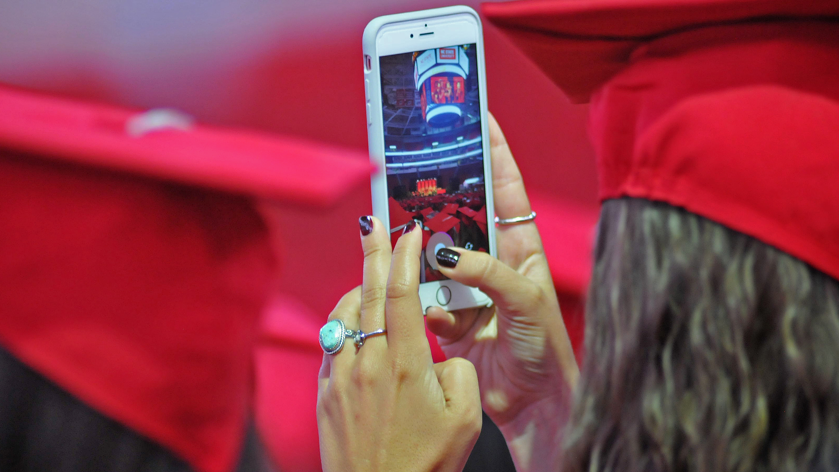 一名毕业生在毕业典礼上用手机拍照。