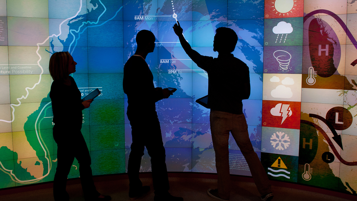 学生在可视化实验室中指着地图。