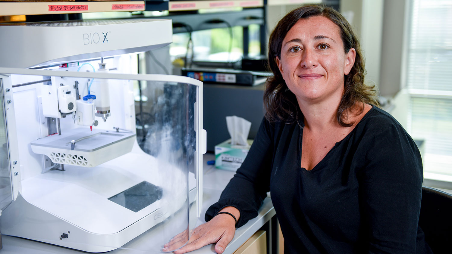 罗斯·索珊尼坐在她用于研究的3D生物打印机旁边