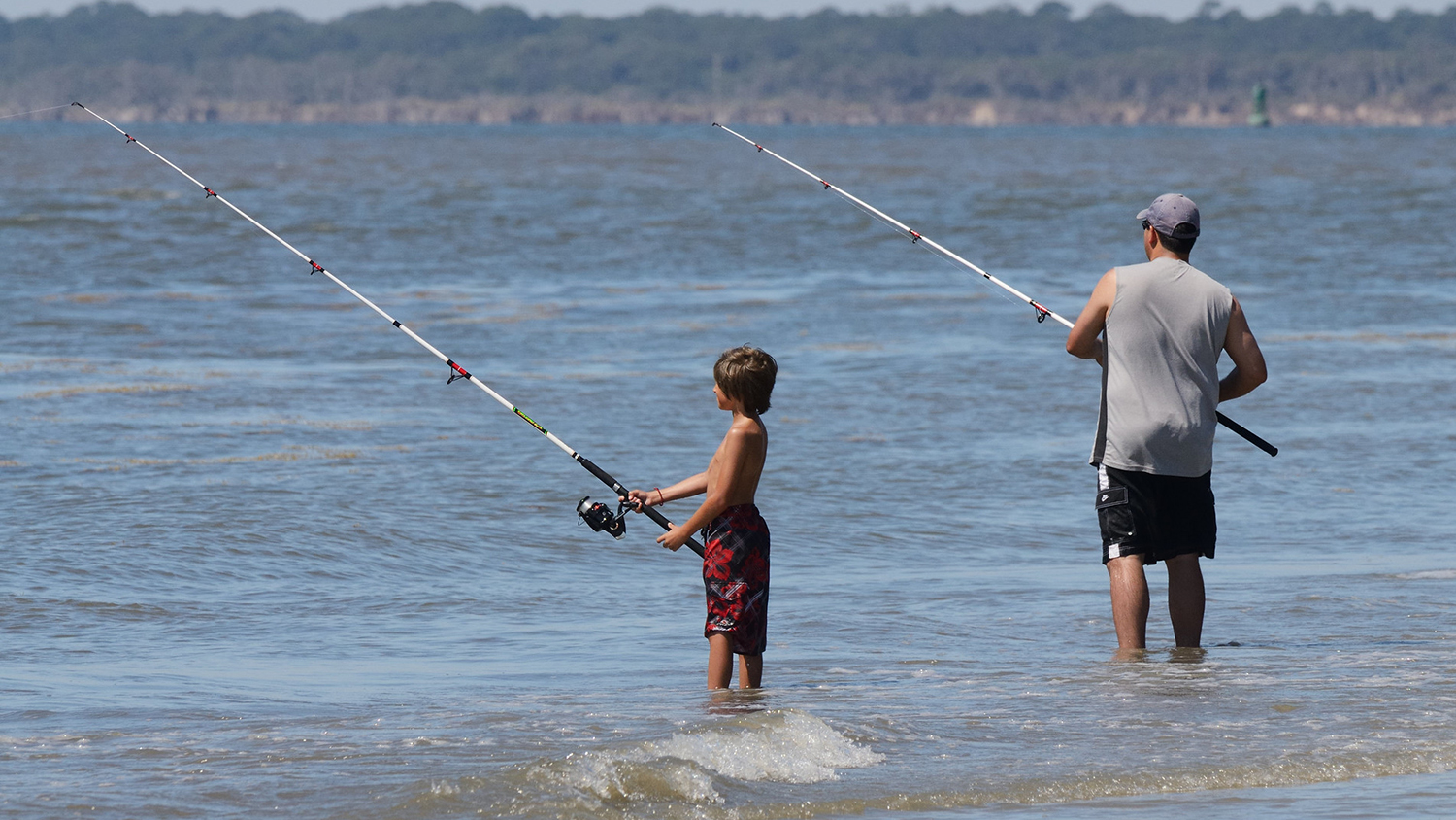 儿童和成人在沙滩上钓鱼