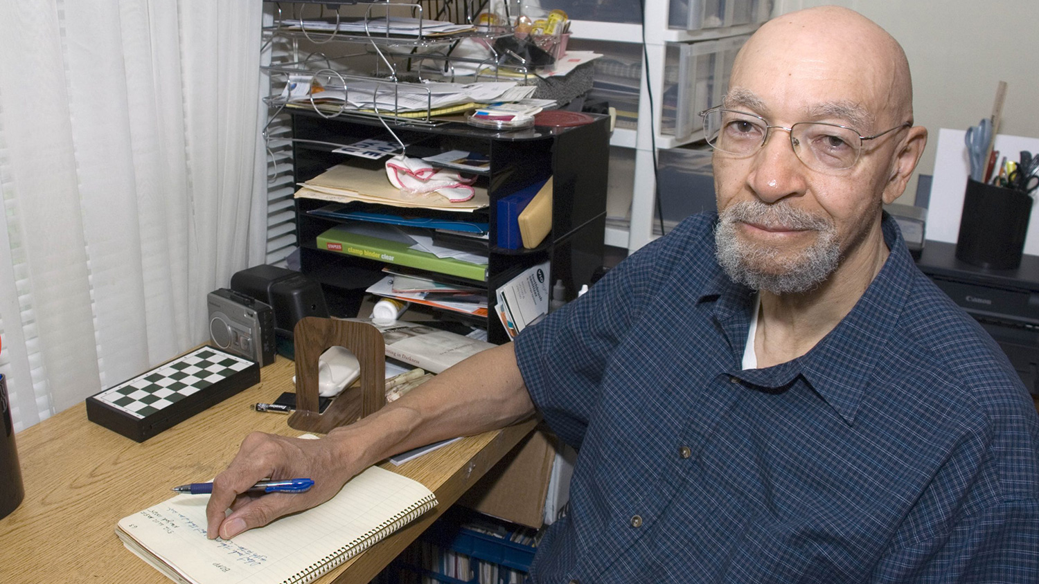 诗人杰拉德·巴拉克斯坐在书桌前。