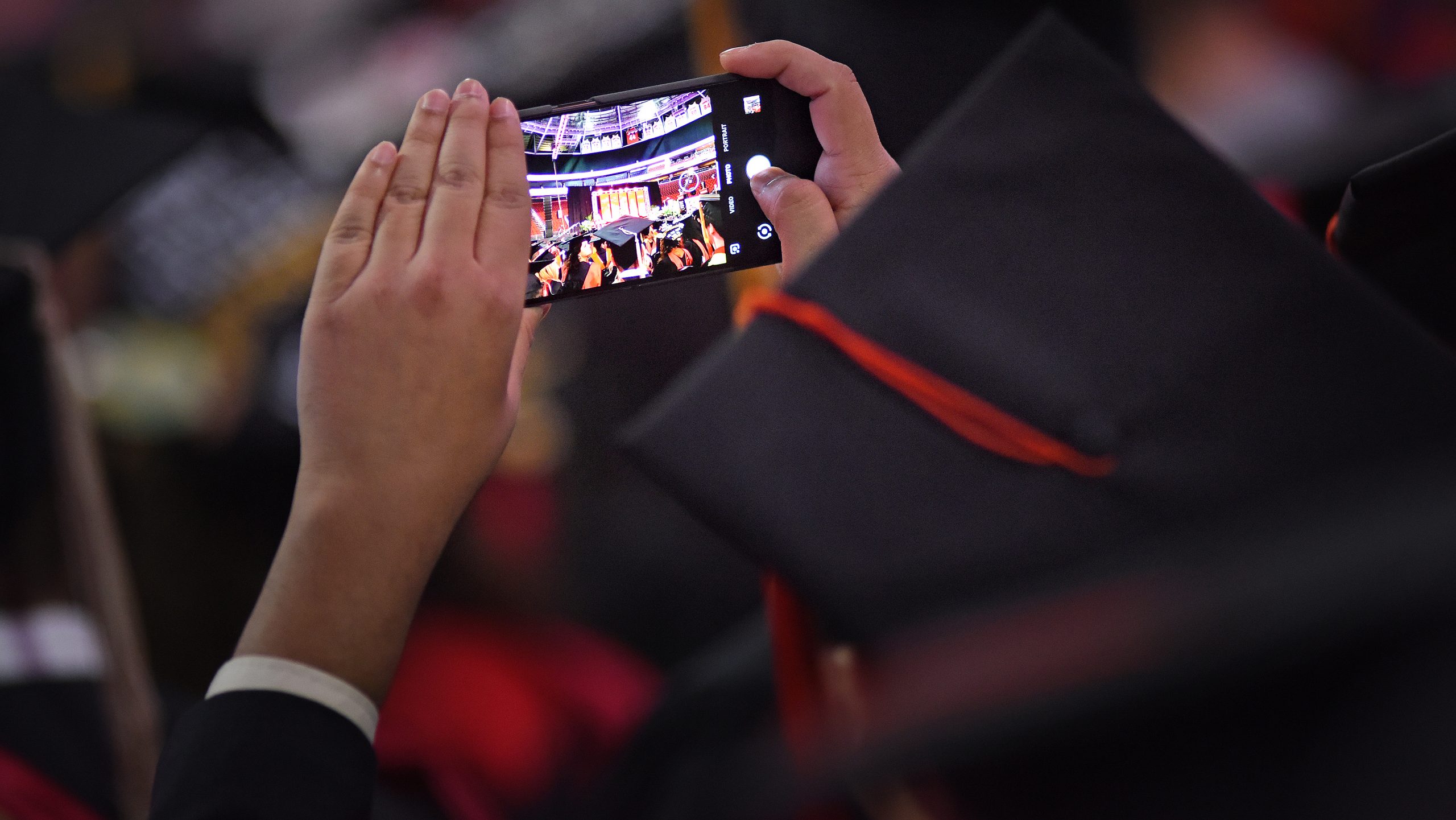 一名研究生在毕业典礼上用手机拍照