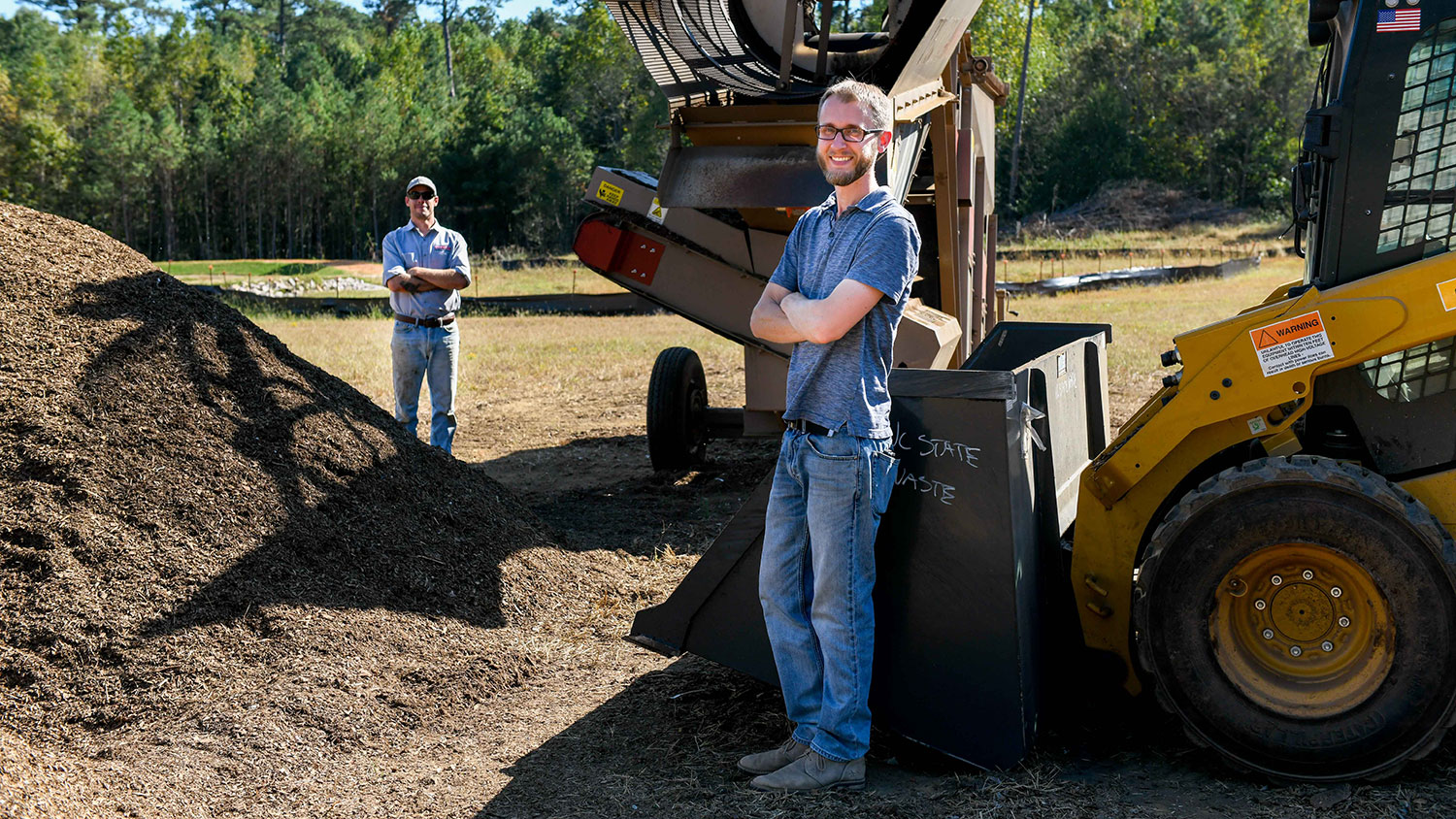 站立在堆肥的两名男子在nc州的堆肥设施