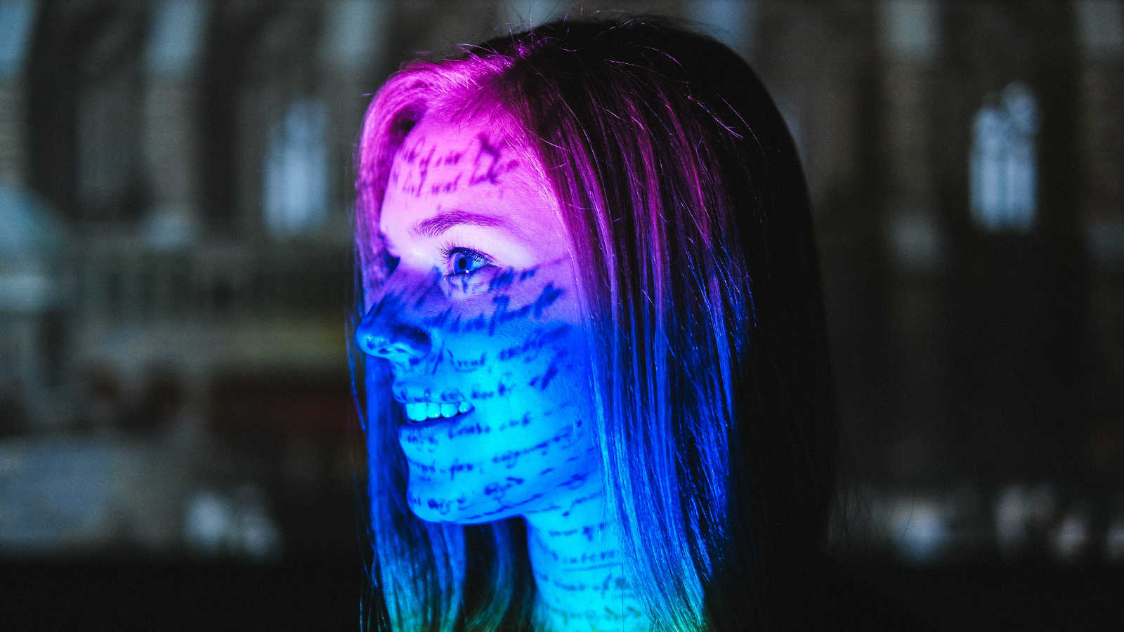 一名年轻女子看着一幅色彩丰富的书法作品。