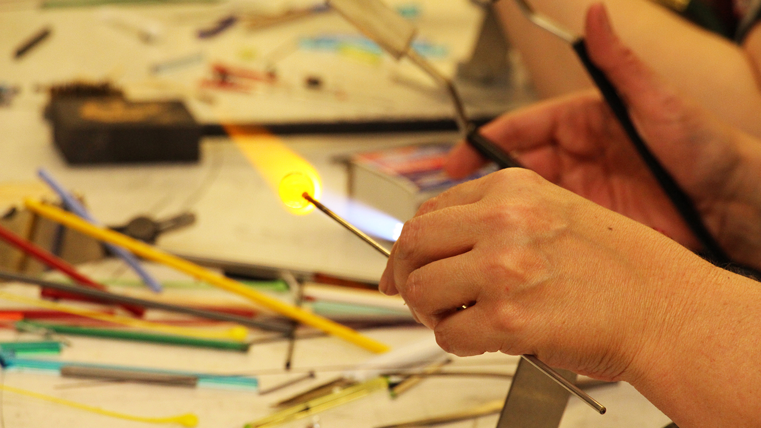 一双用火焰铸造玻璃珠的手。