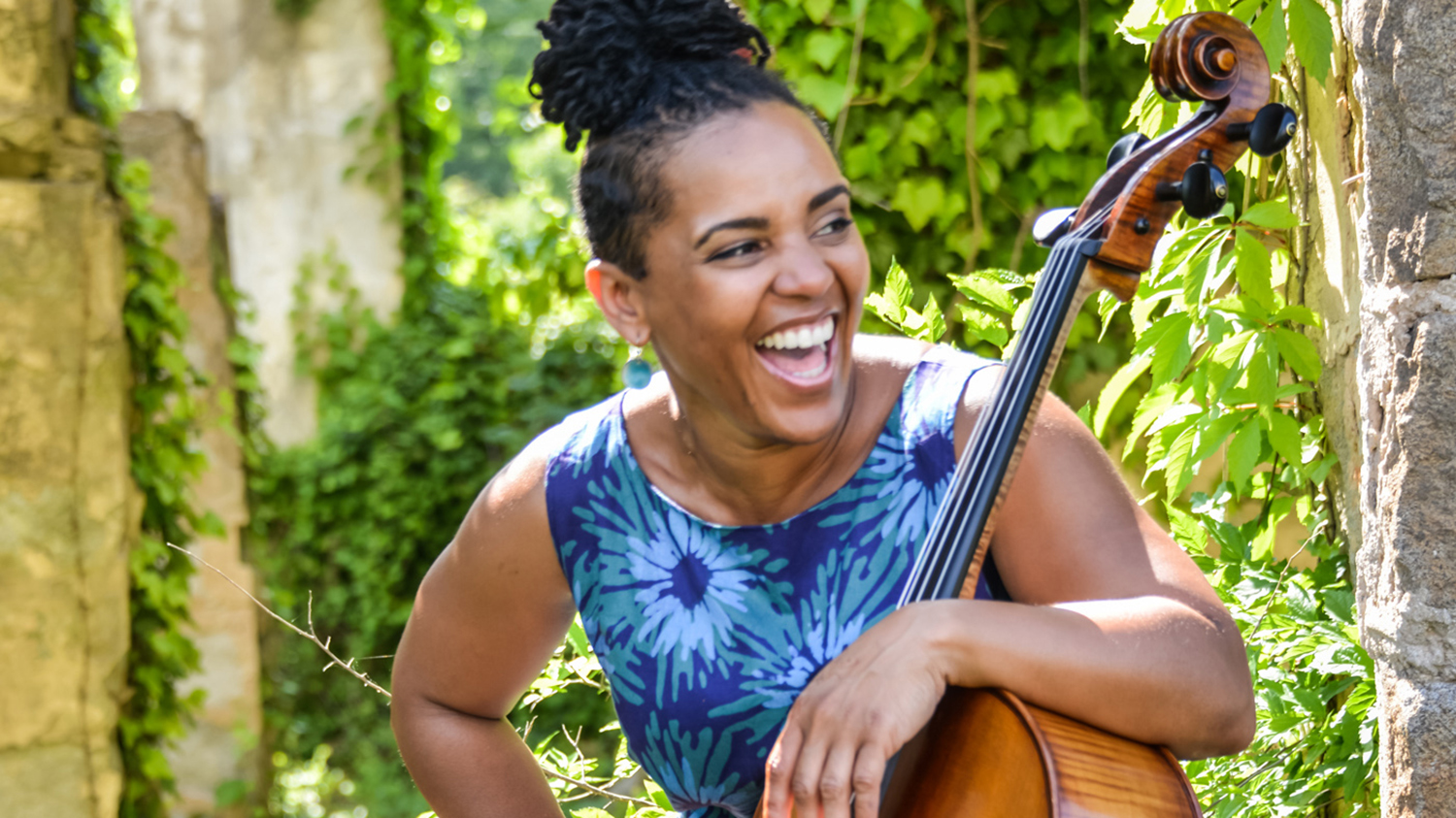 一个大提琴手在花园里微笑。