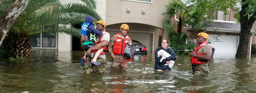 军队人员帮助家人在齐腰深的洪水中撤离