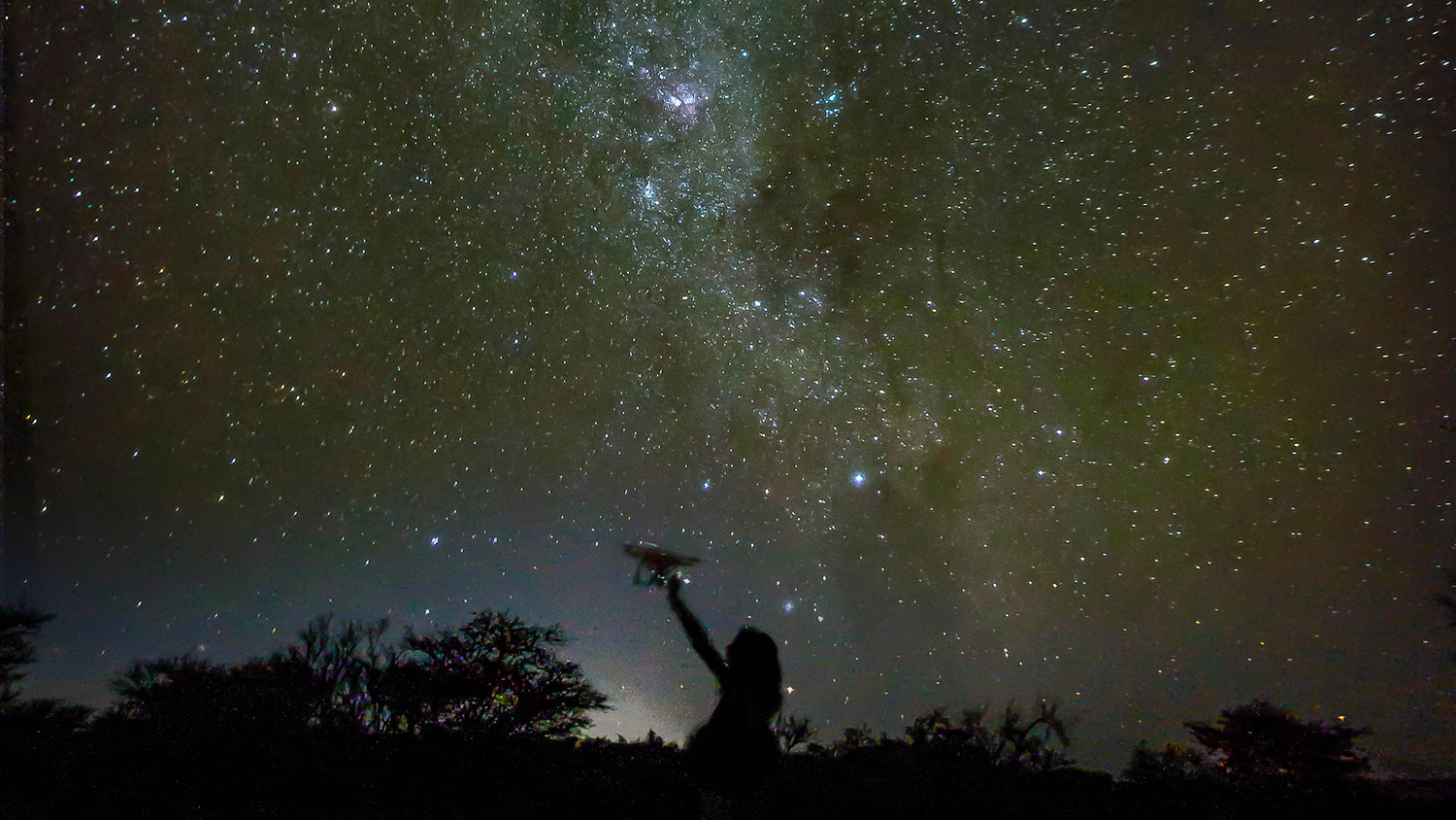 在纳米比亚，一名研究人员正在研究无人机如何探测偷猎者和统计野生动物数量，这张照片与夜晚的银河系放在了一起。