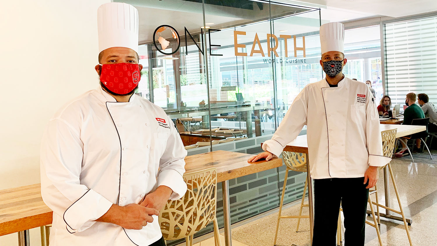 两位厨师站在一家地球餐厅前