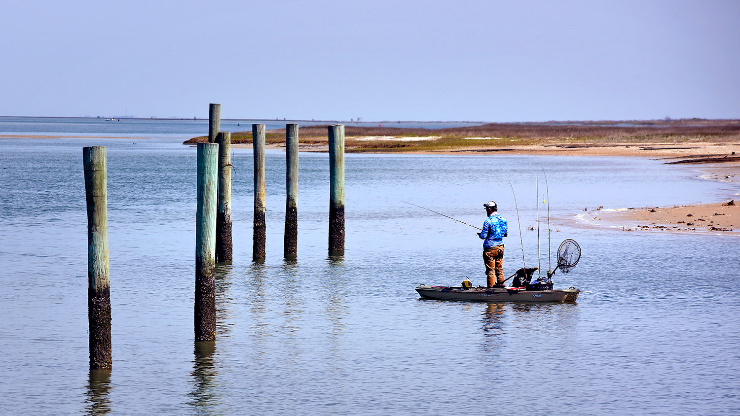 渔夫沿着海角监视海岸线尝试他的运气钓鱼肉豆入口。