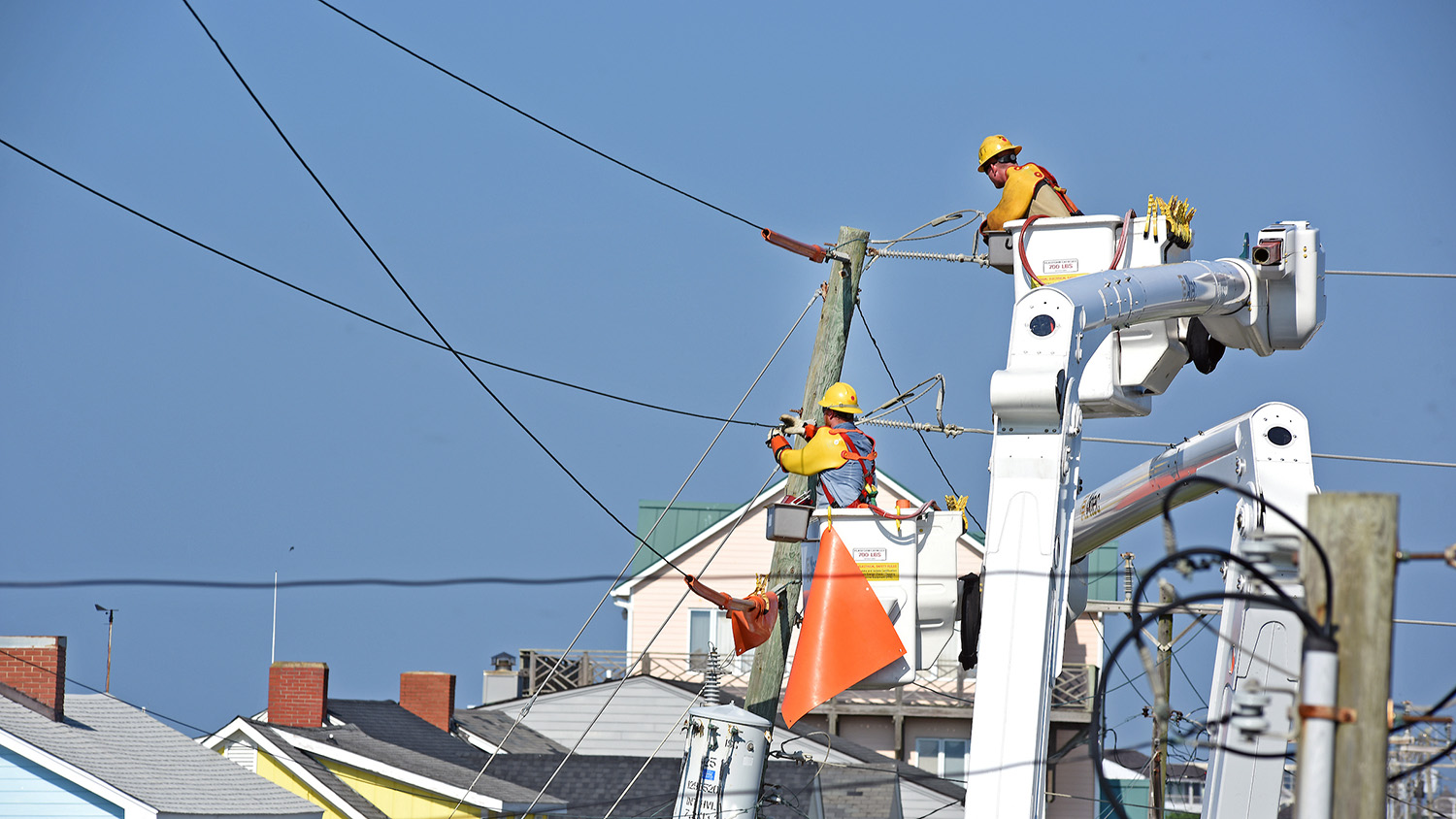 Linemen在大西洋海滩，NC的电气线和杆上工作。