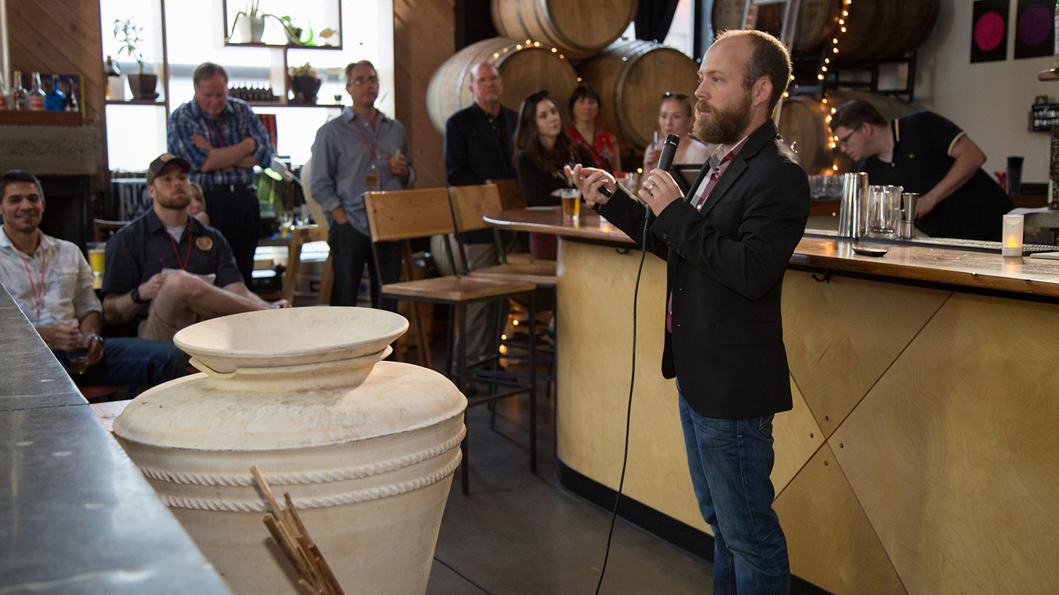 一名男子手持麦克风向人群讲话