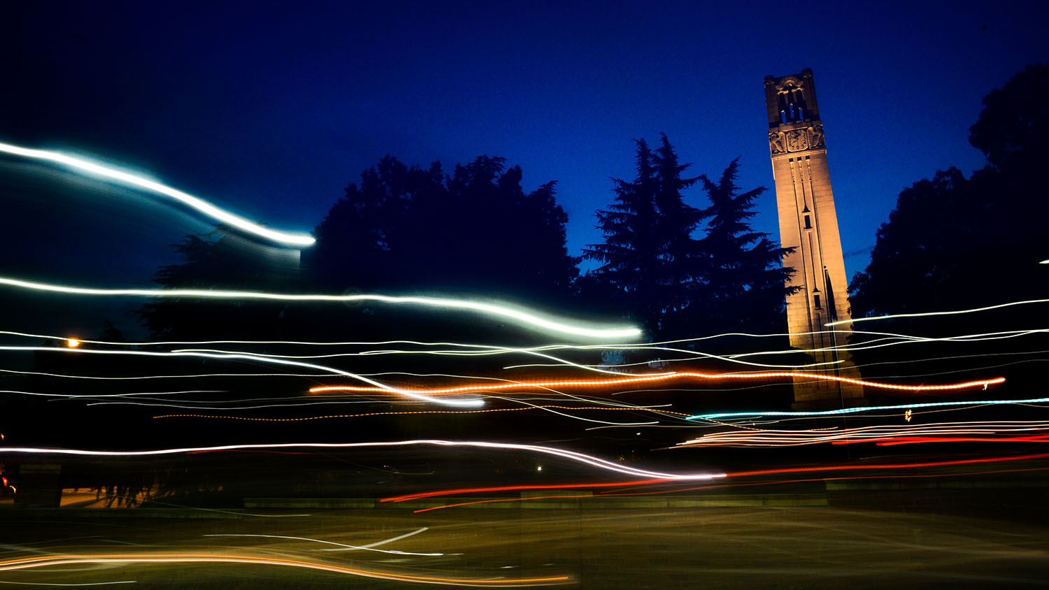 北卡罗来纳州钟塔在黄昏和夜间。照片由马克·霍尔