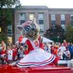 伍夫向北卡罗来纳州立大学的学生们挥手致意，一辆红色的汽车载着她沿着希尔斯伯勒大街行驶。