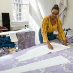 设计工作室的一个女人削减了织物片。