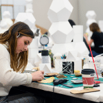 设计演播室的一个少妇在书桌上使用材料工作。