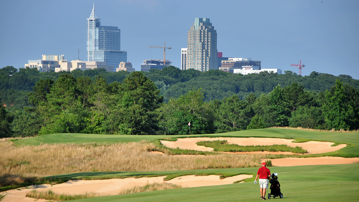 高尔夫球手在Lonnie Poole Golf Course上前往11日绿色。