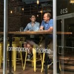 在罗利市中心的一家面包店里，两个人坐在靠窗的座位上聊天。