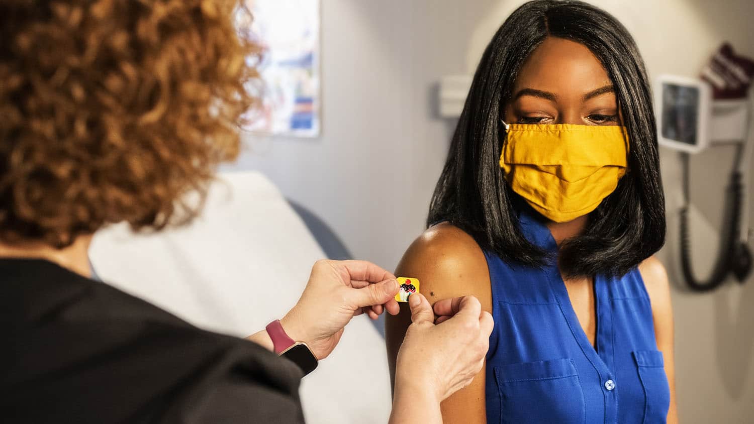 面具的少妇接受疫苗射击