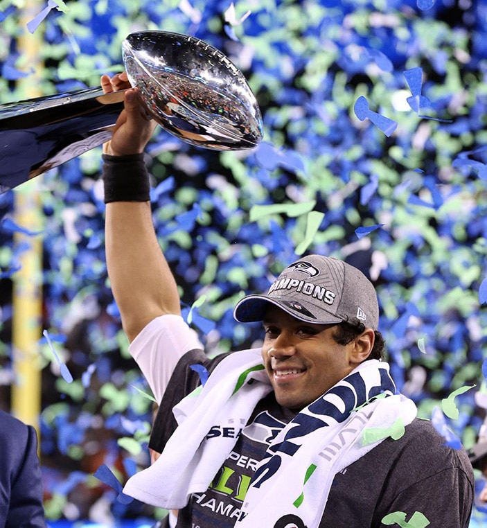 罗素威尔逊在2014年在超级碗XLVIII提升了Vince Lombardi战利品。