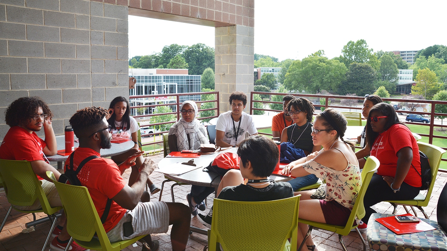 坐在桌子周围的学生参加了多元文化学者研讨会期间的讨论会议