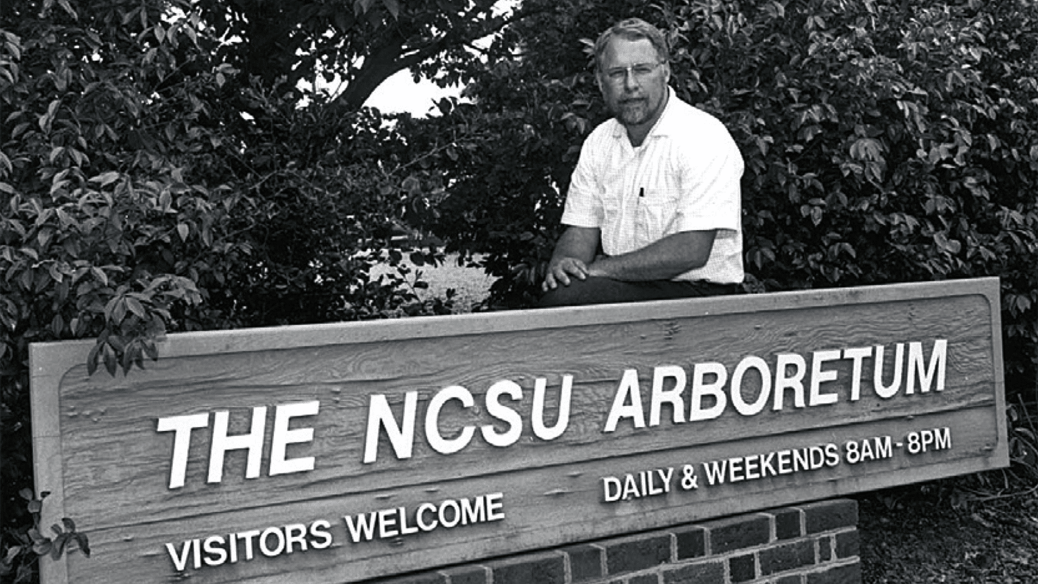 上世纪70年代，J.C.劳斯顿在一块标识NCSU植物园的标牌后面。