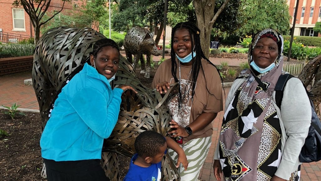 Faduma Osman与她的姐姐，兄弟和母亲在校园里的铜狼雕像