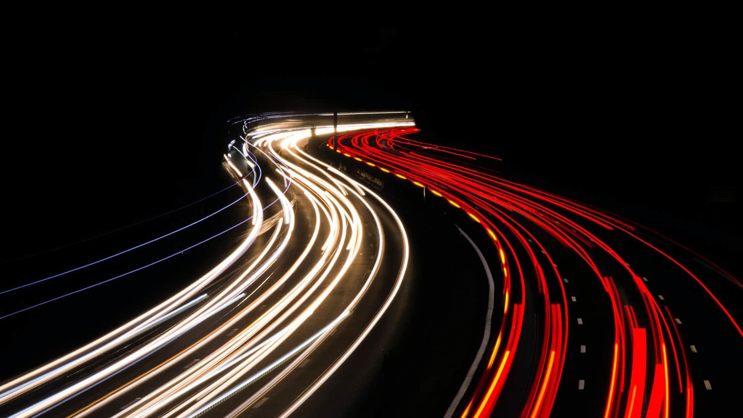 夜间照片显示两条交通线，一个朝向相机移动，一个远离相机