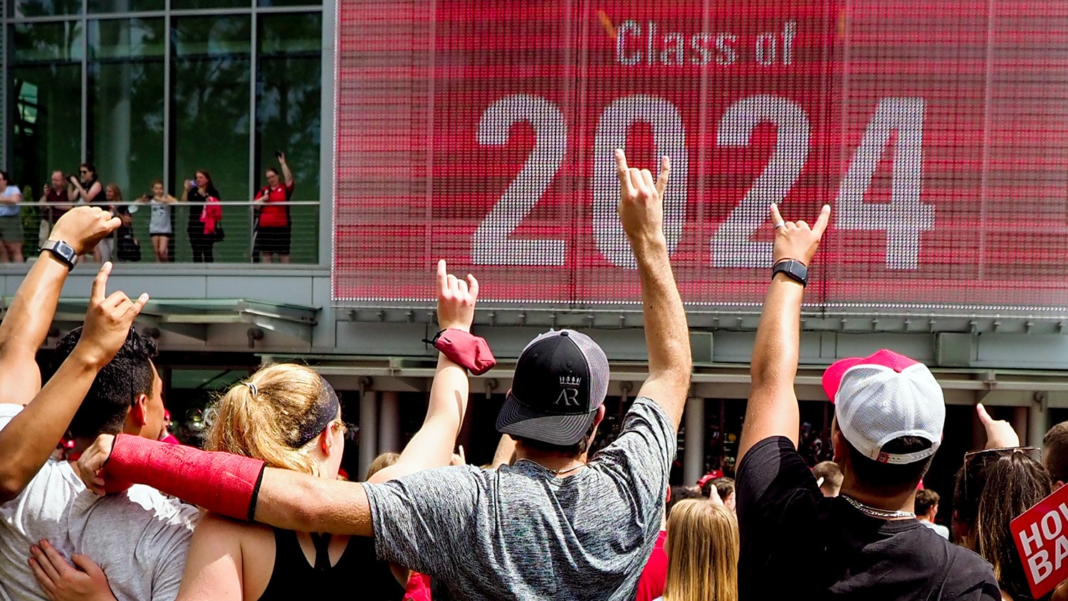 即将入学的北卡罗来纳大学学生在屏幕前做着“狼耳”手势，读着2024年的课程。