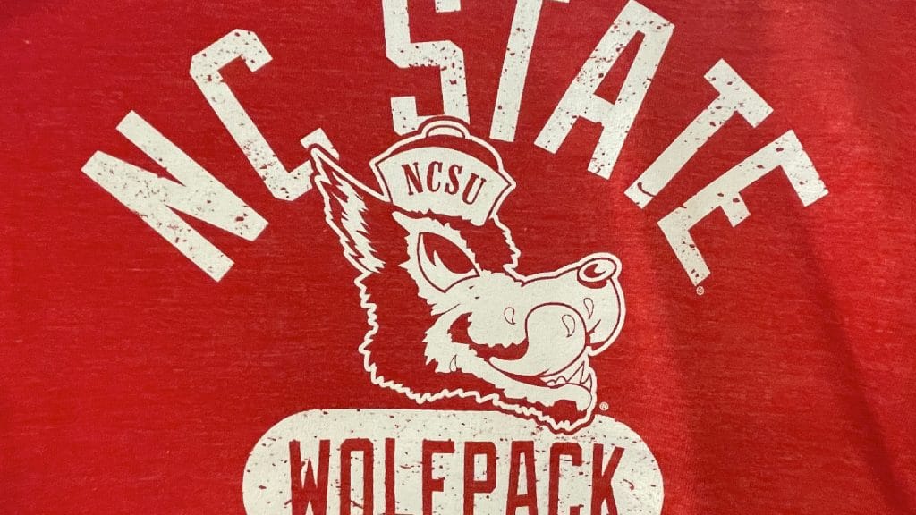 一件红色衬衫上有一只吐着口水的狼的标志。