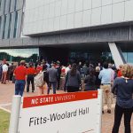 一群人在Fitts-Woolard大厅外站立。