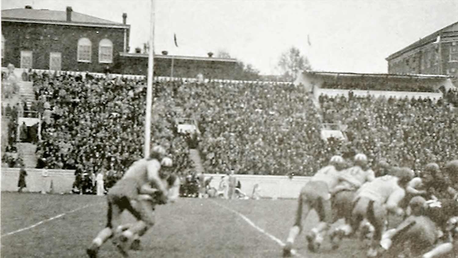 艾迪·伯林斯基和埃弗里特·“牛仔”罗宾逊在一场橄榄球比赛的场地上。