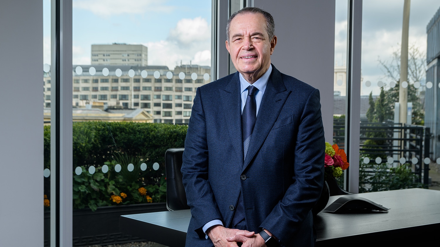 Mohamed L Mansour poses for a photo by a desk