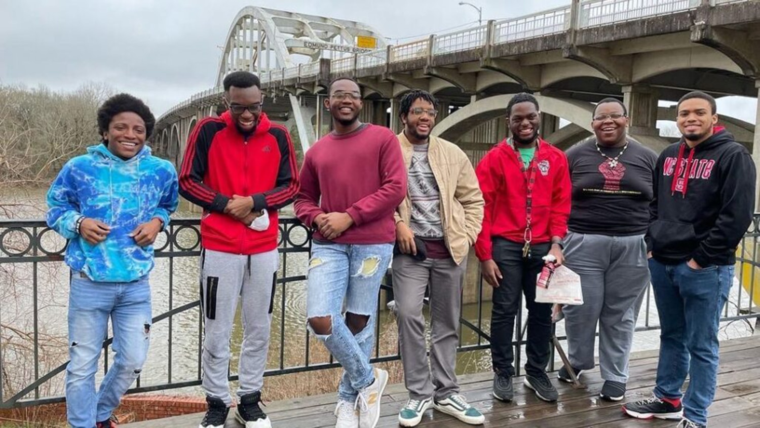 Residents from NC State's Black Male Initiative stand together on a bridge.